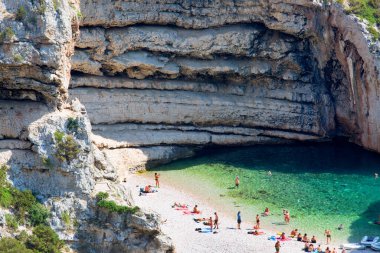 Vis, Vis Adası, Hırvatistan - 5 Eylül 2019: Stiniva Sahili, Adriyatik Denizi Koyu 'ndaki hava manzarası, plajda dinlenen insanlar