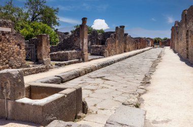 Pompeii, Napoli, İtalya - 26 Haziran 2021: M.S. 79 'da Napoli yakınlarında Vesuvius volkanının patlaması sonucu yıkılan antik bir şehrin kalıntıları. Şehir sokaklarından birinin manzarası