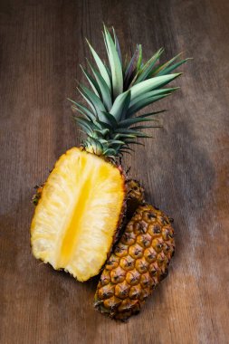 Ananas meyve ahşap arka plan üzerinde görüntülenen ikiye ayırmak. Organik olarak yetiştirilen olgun ve tatlı sulu