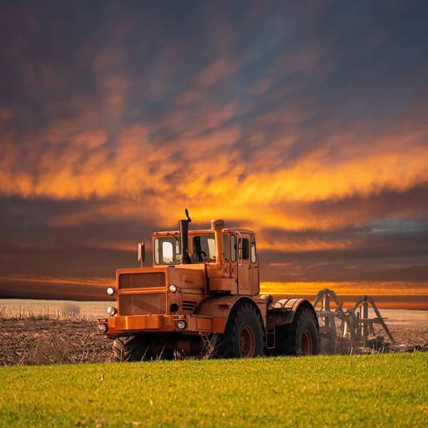 在日出时培育田地的拖拉机 — 图库照片