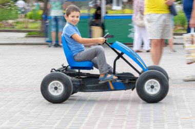 Yaz aylarında genel Park mavi bir pedallı araba sürme çocuk