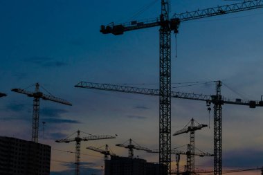Gün batımında inşaat vinçleri