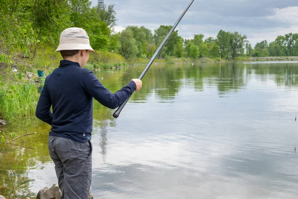 曇りの日に川で魚を捕まえる少年 — ストック写真