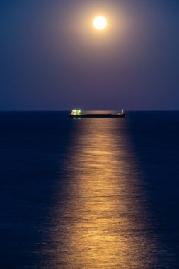 Ufukta dolunay varken gece kargo gemisi