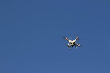 Mavi gökyüzü arka plan quadrocopter üzerinde beyaz uçan uçak