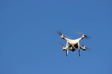 Mavi gökyüzü arka plan drone üzerinde beyaz uçan quadrocopter