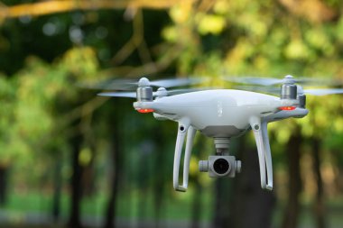Yeşil ağaçlar arka plan quadrocopter kamera ile beyaz uçan uçak