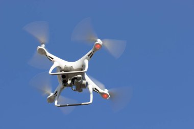 Mavi gökyüzü arka plan quadrocopter üzerinde beyaz uçan uçak