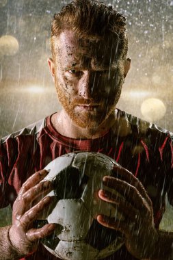 Profesyonel futbol gece yağmur stadyumda futbolcu. Futbol topu ile yağmur damlakirli oyuncu