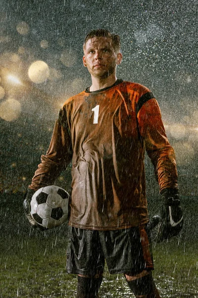 足球守门员在职业足球夜雨体育场 脏球员在雨中滴与足球 — 图库照片