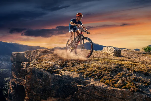 Cross-Country biker on trail. Male cyclist rides the rock