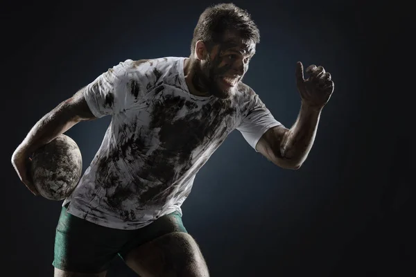 Vereinzelter Schmutziger Rugbyspieler Mit Rugbyball Auf Dunklem Hintergrund — Stockfoto