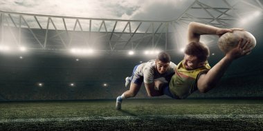 İki erkek Rugby oyuncuları profesyonel rugby stadyumunda uçuş topu için mücadele