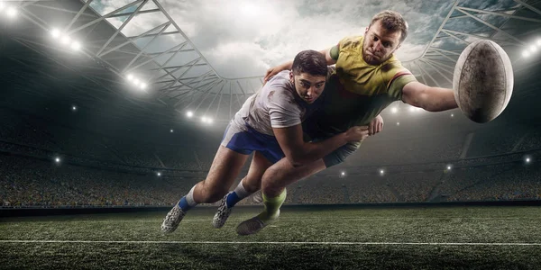 Two male Rugby players fight for the ball in flight on professional rugby stadium