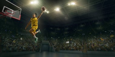 Kadın basketbolcu smaç yapıyor. Basketbolcu oyun sırasında büyük profesyonel arenada