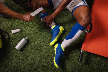 Futbol oyuncusu diz yaralandı oyun sırasında. Spor doktorlar profesyonel bir futbol alanında oyuncuya ilk yardım sağlar. Yakın çekim