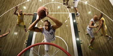 Oyun sırasında büyük profesyonel arenada basketbol oyuncuları. Basketbolcu gecekondu smaç yapar. Basketbol potası üzerinden en iyi görüntü