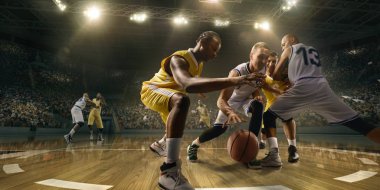 Oyun sırasında büyük profesyonel arenada basketbol oyuncuları. Erkek basketbolcular top için savaşıyor