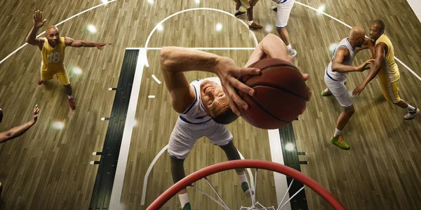 Basketball players on big professional arena during the game. Basketball player makes slum dunk. Top view through the basketball hoop