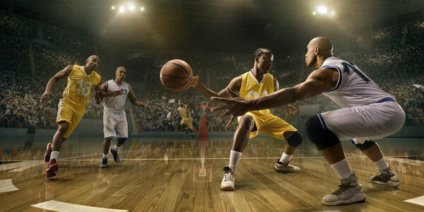 Basketball players on big professional arena during the game. Male basketball players fight for the ball