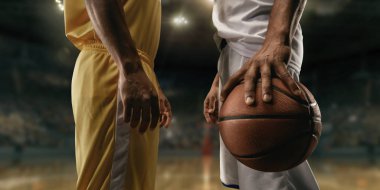 Maçtan önce büyük profesyonel arenada basketbol oyuncuları. İki takım. Oyuncular yüz yüze çarpıştı. Oyuncu bir top tutar