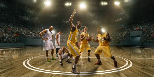 篮球运动员在职业篮球场上为胜利而欢欣鼓舞 来自对方球队的球员因为失败而伤心 — 图库照片