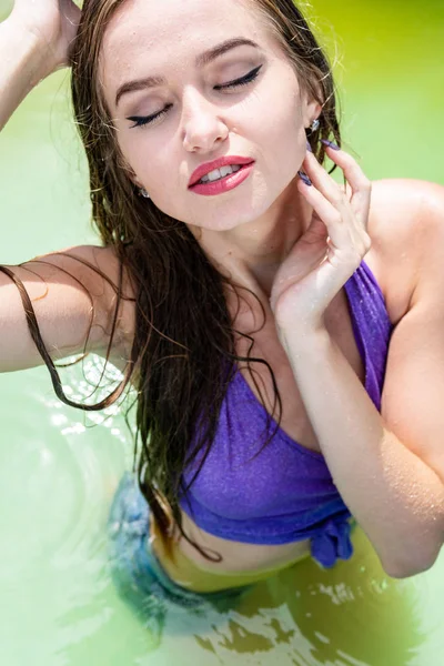 Wet model takes a shower and swims in clothes, wet clothing, Wet Look women's, sauna and swimming pool.
