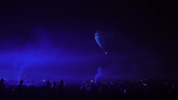 Night glow hot air balloon community festival. Pilot prepare to take slow moving hot air balloons. Fire heats inside of colorful fabric. Evening night dark rural community. — Stock Video