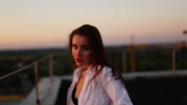 Chica joven en uniforme deportivo se sienta en el borde del techo durante el atardecer . —  Fotos de Stock