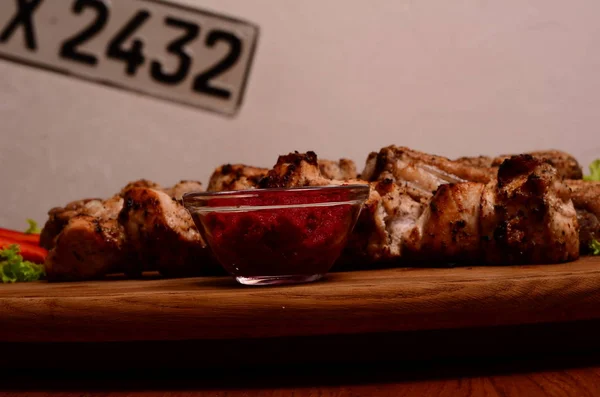 Grilled meat and vegetables on rustic wooden table.