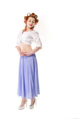 Redheaded girl in hair curlers in lilac skirt, a white topography and isolated on a white background