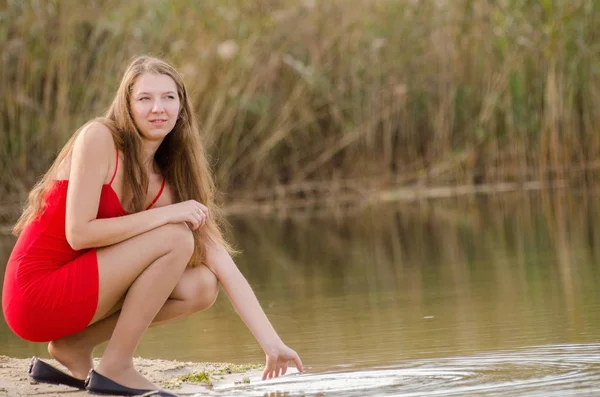 Jeune femme en robe rouge nature air frais — Photo