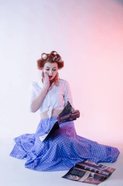 Redheaded girl in hair curlers in lilac skirt, a white topography and isolated on a white background
