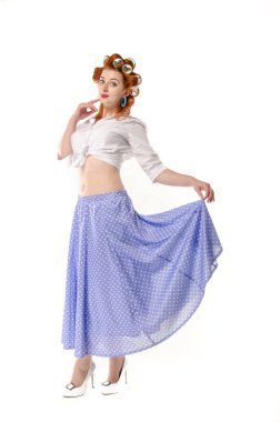 Redheaded girl in hair curlers in lilac skirt, a white topography and isolated on a white background