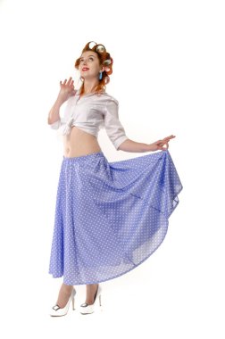 Redheaded girl in hair curlers in lilac skirt, a white topography and isolated on a white background