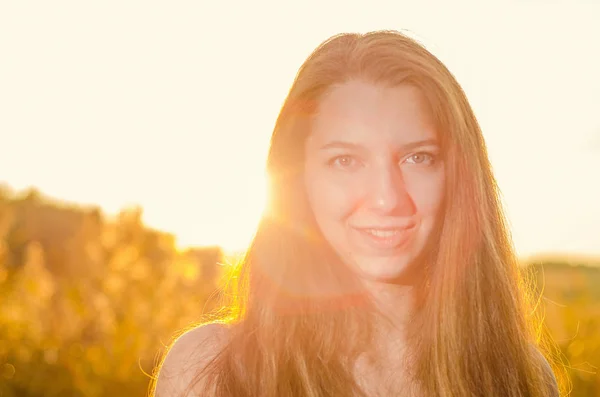 Beautiful girl in a posh red dress posing on a poppy field. Poppy field at sunset. Art processing. Sunset — Stock Photo, Image