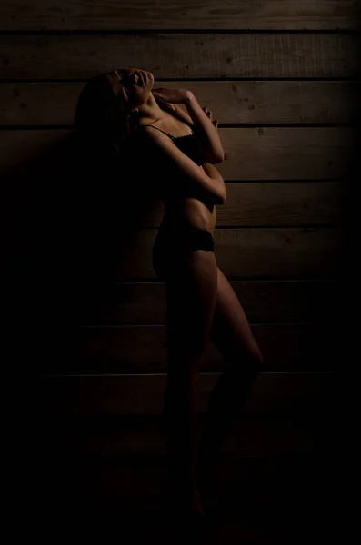 Mooi sexy meisje in een zwart badpak op een achtergrond van gepolijste platen — Stockfoto