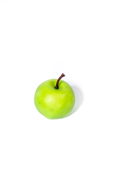 แอปเปิ้ลสีเขียวประดิษฐ์บนพื้นหลังสีขาว ตัดส่วนใกล้ชิด — ภาพถ่ายสต็อก