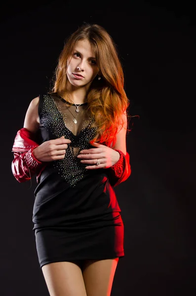 Jong mooi sexy meisje op een zwarte achtergrond in jurk studio foto. — Stockfoto