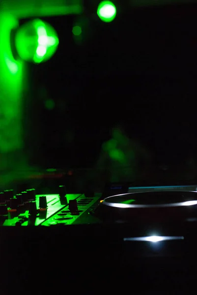 DJ mixer met een koptelefoon bij nightclub. In de achtergrond-laserlicht — Stockfoto