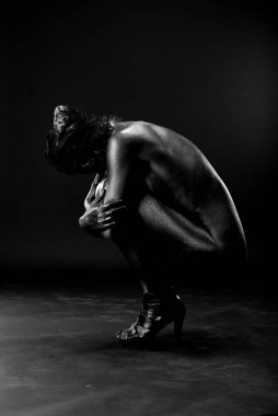 Çıplak kadın stüdyoda beyaz bir arka plan üzerinde siyah boyalı.