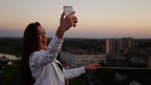 Plenerowej piękna dziewczyna biorąc selfie na dachu. — Zdjęcie stockowe