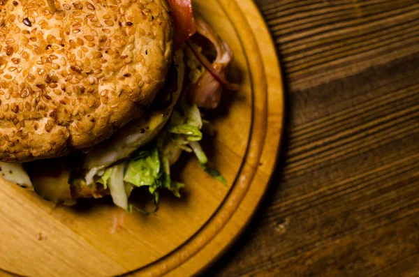 Hambúrguer de bacon com carne bovina em mesa de madeira — Fotografia de Stock
