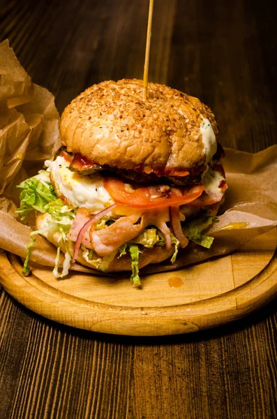 Bacon burger with beef patty on wooden table — Stock Photo, Image