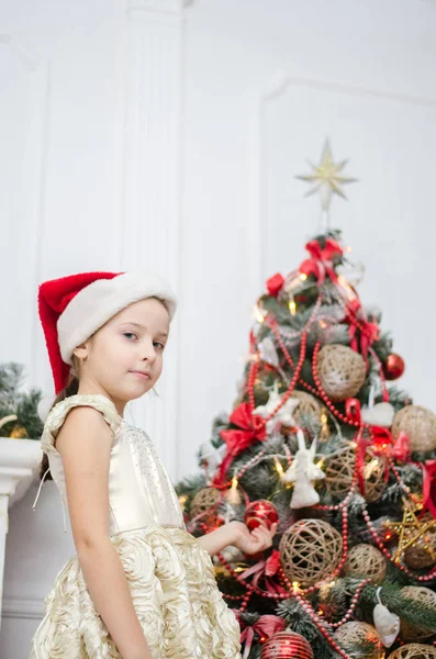 Gelukkig kind meisje in een kerstmuts wachten op een wonder Stockfoto