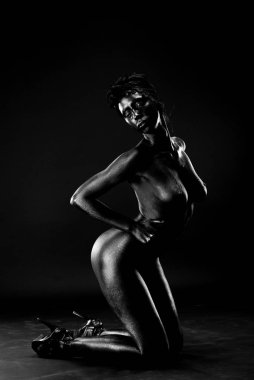 Çıplak kadın stüdyoda beyaz bir arka plan üzerinde siyah boyalı.