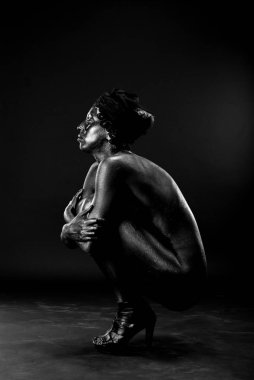 Çıplak kadın stüdyoda beyaz bir arka plan üzerinde siyah boyalı.