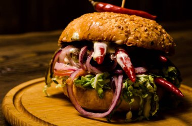 Pastırmalı hamburger ve ahşap masa.