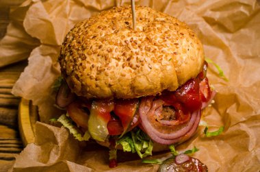 Pastırmalı hamburger ve ahşap masa.