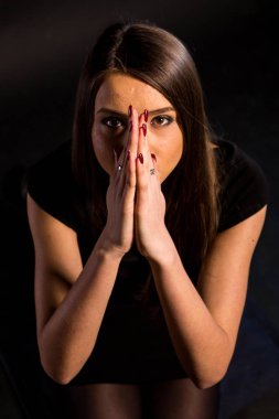 güzel makyaj ve iyi bir cilt ile siyah elbiseli güzel bir genç kadının portresi. Stüdyo, siyah arka plan.